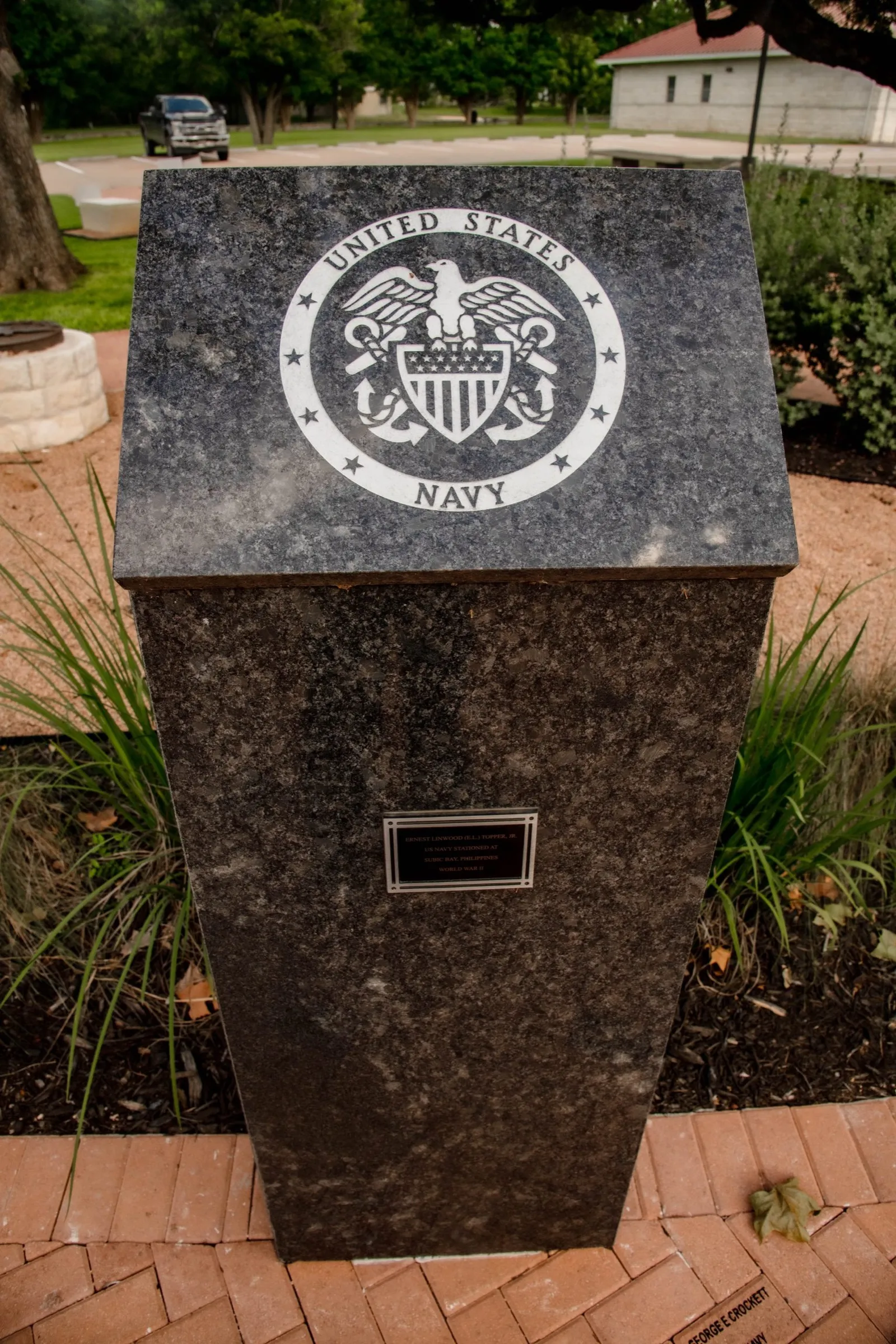 A granite marker engraved with a military service seal at the memorial